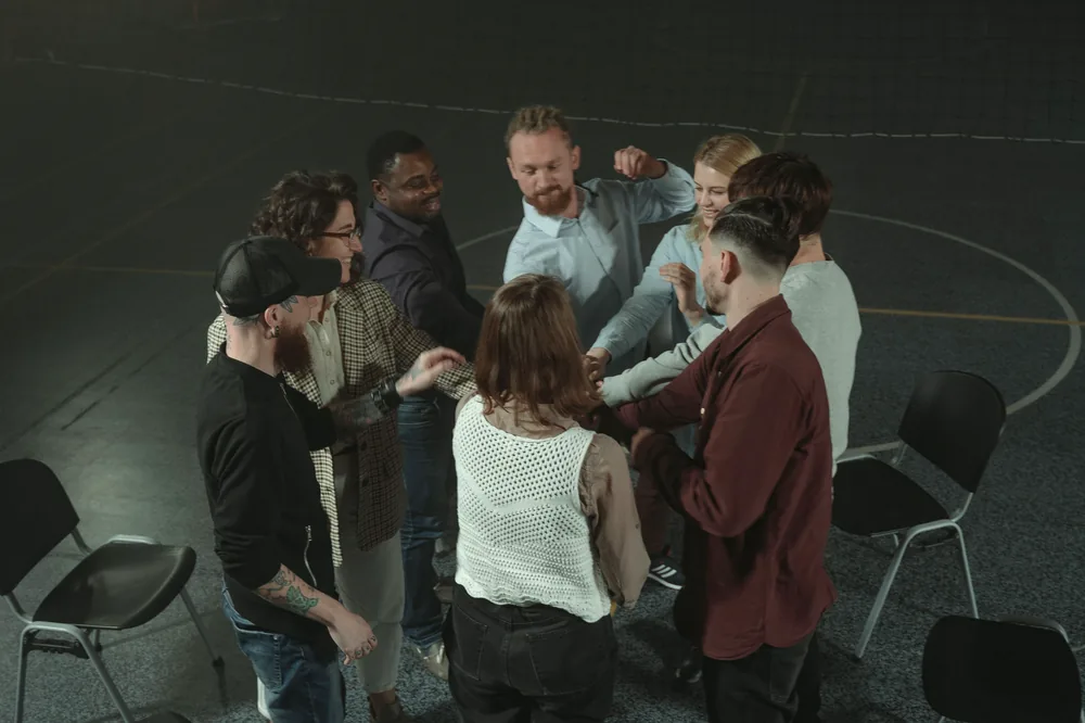 A therapy group standing in a circle together at the close of a session