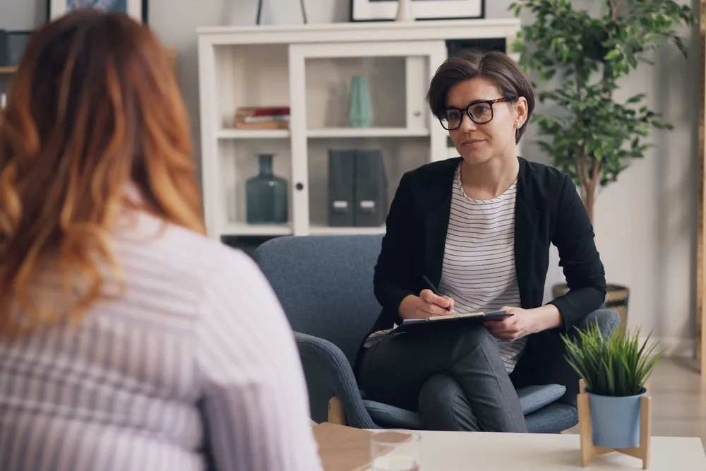 Two people talking during a one-on-one counseling session in a bright office